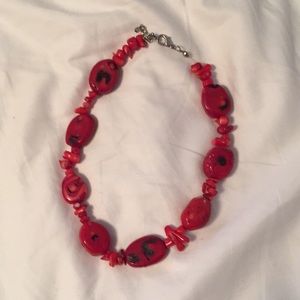 Red gemstone necklace. Maybe jasper or carnelian.